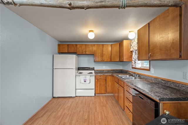 1205 Fairwood Dr SW, Ocean Shores, WA 98569 - kitchen with dark countertops, light wood-type flooring, brown cabinetry, white appliances, and a sink