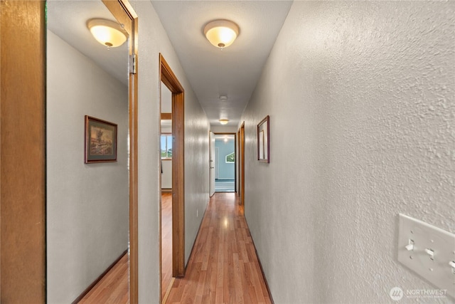 1205 Fairwood Dr SW, Ocean Shores, WA 98569 - corridor featuring light wood-type flooring, baseboards, and a textured wall
