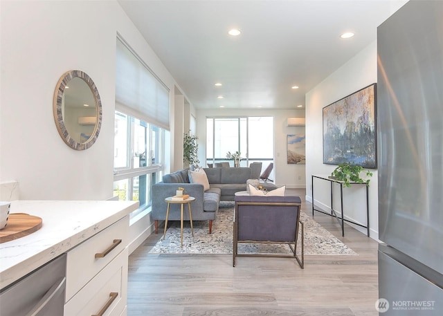 living area with recessed lighting, light wood-style flooring, and baseboards
