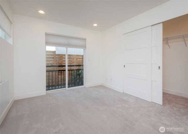 unfurnished bedroom featuring baseboards, recessed lighting, carpet, and a closet