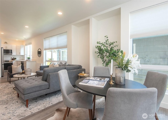 dining room with recessed lighting and light wood-style flooring