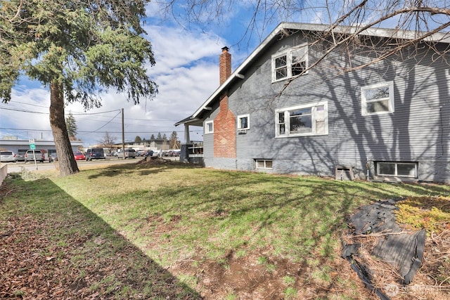 view of property exterior featuring a yard and a chimney
