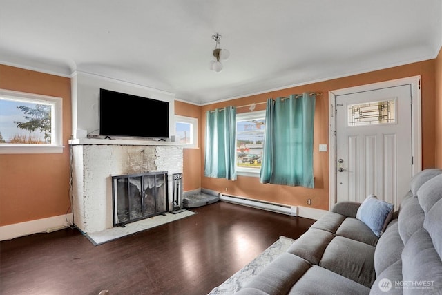 living room featuring a baseboard radiator, wood finished floors, ornamental molding, and a stone fireplace
