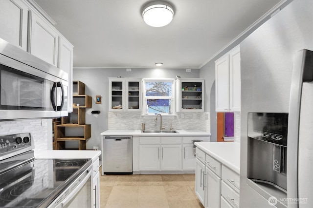 kitchen with white cabinetry, appliances with stainless steel finishes, light countertops, a sink, and decorative backsplash