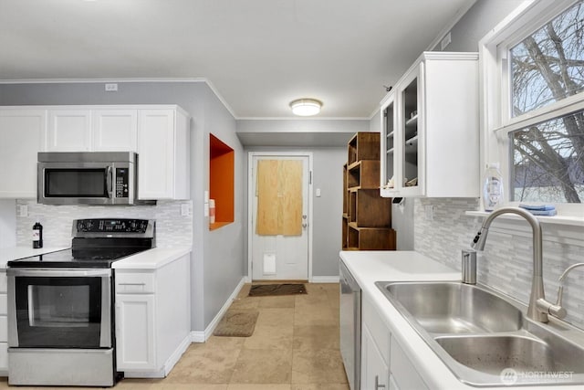 kitchen with stainless steel appliances, white cabinets, light countertops, and a sink