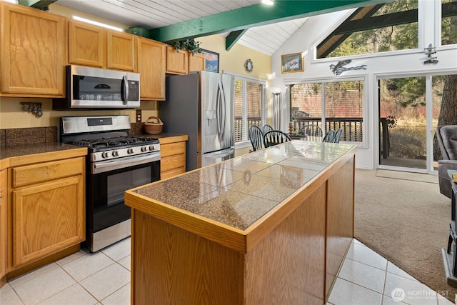 1081 Wapiti Dr, Cle Elum, WA 98922 - kitchen with appliances with stainless steel finishes, tile countertops, beam ceiling, light tile patterned floors, and a center island