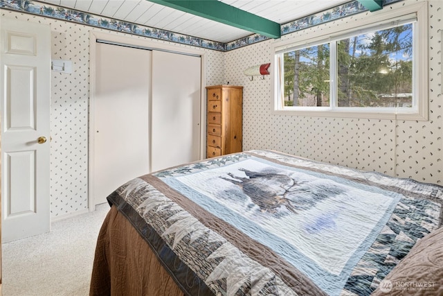 1081 Wapiti Dr, Cle Elum, WA 98922 - carpeted bedroom with wallpapered walls, a closet, and beamed ceiling