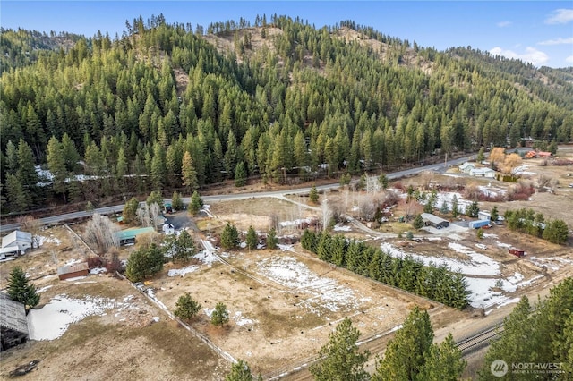 drone / aerial view featuring a wooded view