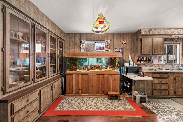 kitchen featuring stainless steel microwave, light countertops, and a sink