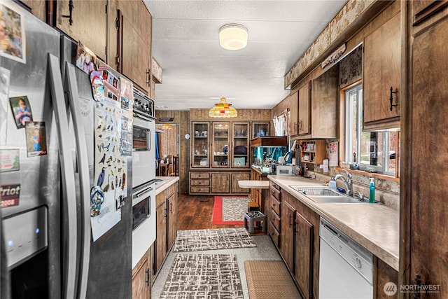 kitchen with light countertops, brown cabinets, appliances with stainless steel finishes, and a sink