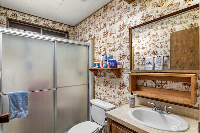 bathroom featuring toilet, a stall shower, wallpapered walls, and vanity