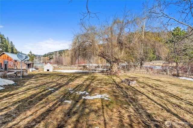 view of yard with an outbuilding, a storage shed, and fence