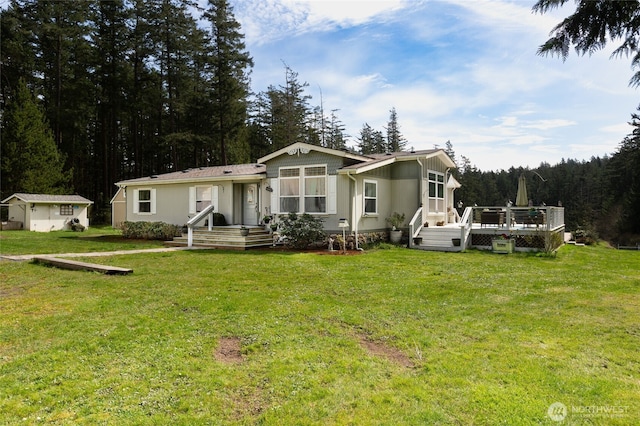 back of property featuring a lawn and a deck