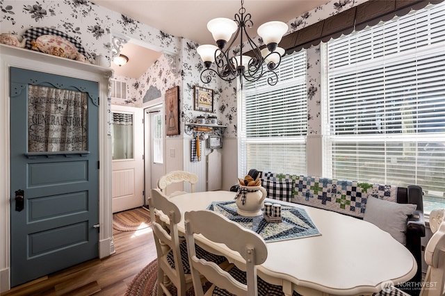 dining space featuring an inviting chandelier, wallpapered walls, and a wealth of natural light