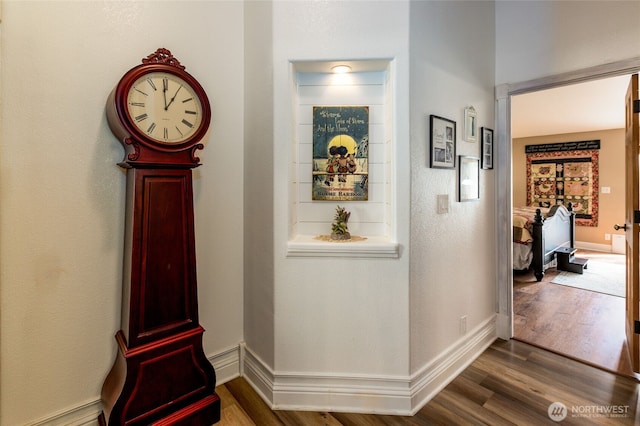 hall featuring dark wood-style floors and baseboards