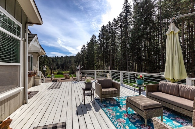 wooden deck featuring a forest view and an outdoor hangout area