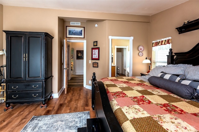 bedroom with dark wood-style flooring, visible vents, and baseboards