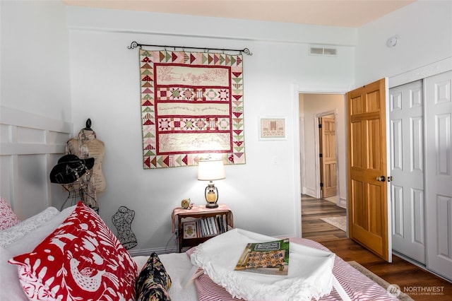bedroom featuring visible vents, a closet, and wood finished floors