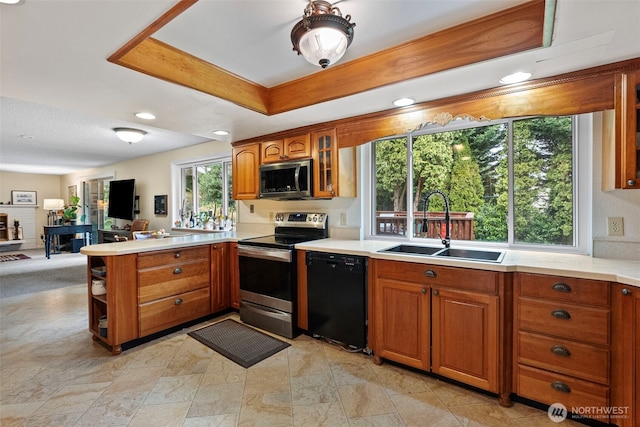 2913 SE Forest Villa Ct, Port Orchard, WA 98366 - kitchen with appliances with stainless steel finishes, a peninsula, brown cabinets, light countertops, and glass insert cabinets