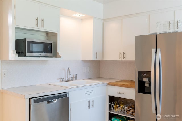 4200 N Pl, Seaview, WA 98644 - kitchen featuring appliances with stainless steel finishes, backsplash, light countertops, and white cabinetry