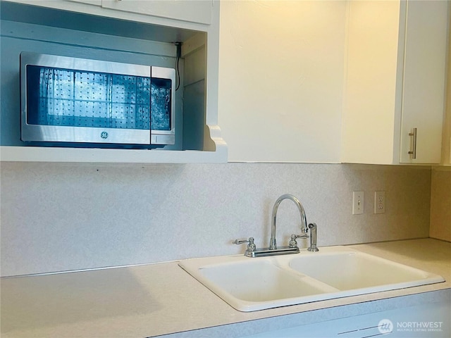 4200 N Pl, Seaview, WA 98644 - kitchen view of stainless steel microwave, white cabinets, light countertops, and decorative backsplash