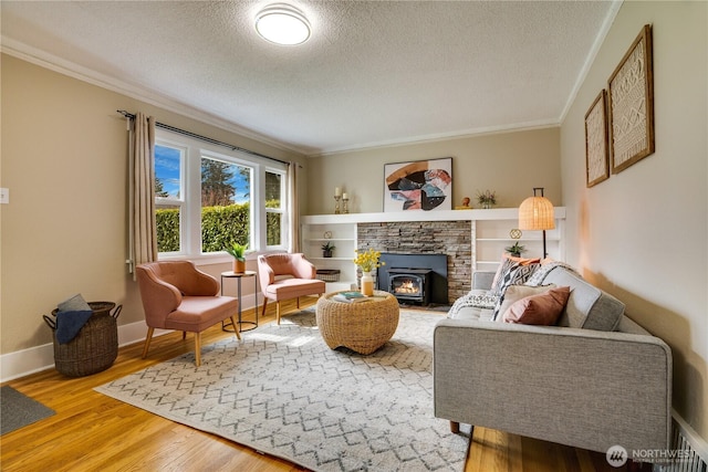 living area featuring baseboards, wood finished floors, ornamental molding, and a textured ceiling