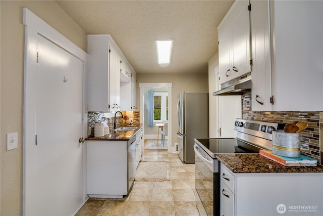 kitchen featuring decorative backsplash, stainless steel appliances, under cabinet range hood, white cabinetry, and a sink