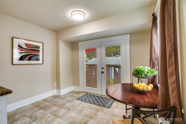 doorway with baseboards, french doors, and a textured ceiling