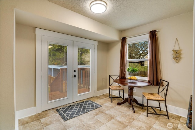 dining space with baseboards, french doors, and a textured ceiling