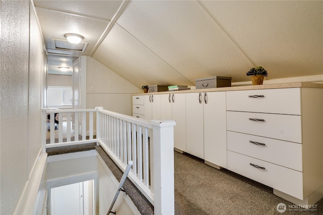 corridor featuring lofted ceiling and an upstairs landing