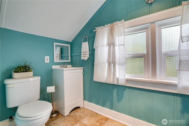 half bath featuring toilet, vaulted ceiling, tile patterned flooring, and vanity