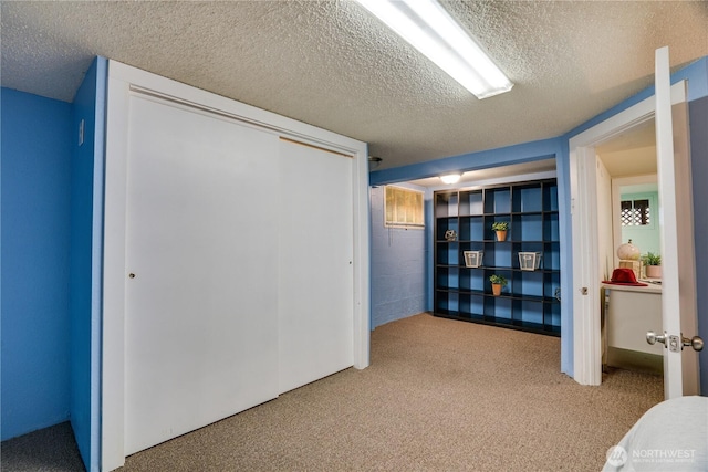 unfurnished bedroom featuring a closet, carpet flooring, and a textured ceiling