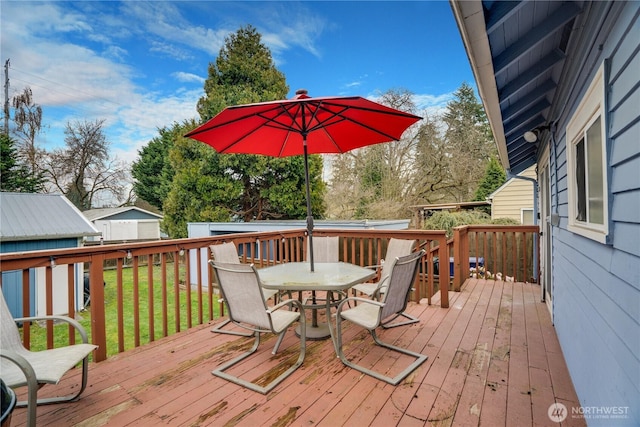 deck with a lawn and outdoor dining area