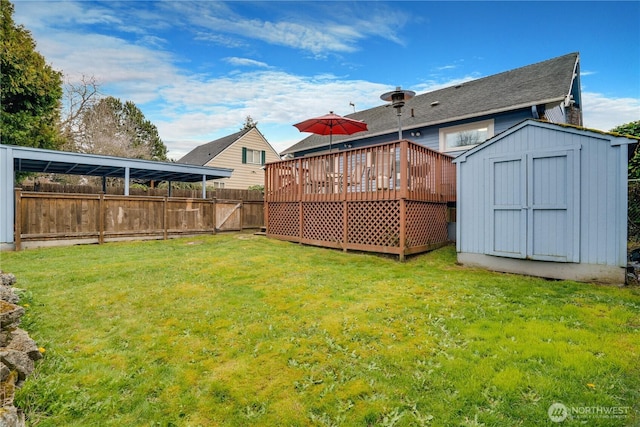 view of yard featuring an outbuilding, fence, a storage shed, and a deck