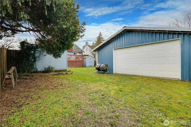 view of yard with an outbuilding, a storage unit, and fence