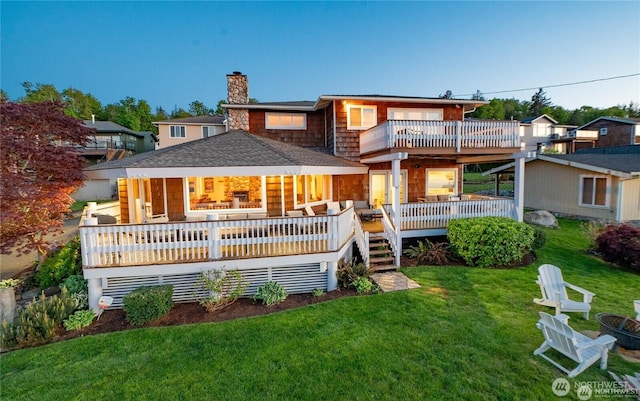 6926 Holeman Ave, Blaine, WA 98230 - rear view of house featuring a lawn, a deck, roof with shingles, a balcony, and a chimney
