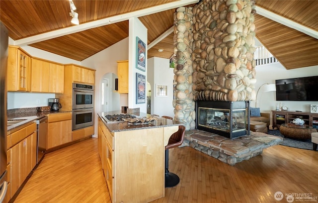 6926 Holeman Ave, Blaine, WA 98230 - kitchen featuring stainless steel appliances, arched walkways, open floor plan, and light brown cabinetry