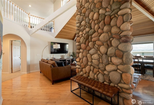 6926 Holeman Ave, Blaine, WA 98230 - living area featuring light wood-type flooring, arched walkways, baseboards, and a towering ceiling