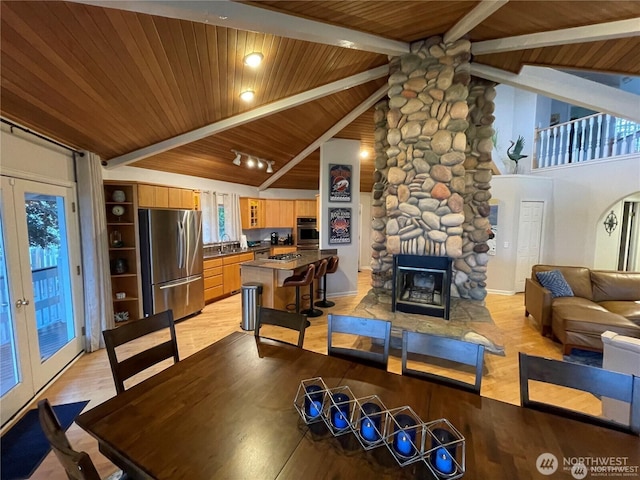6926 Holeman Ave, Blaine, WA 98230 - dining area with light wood-type flooring, beamed ceiling, wooden ceiling, and a fireplace