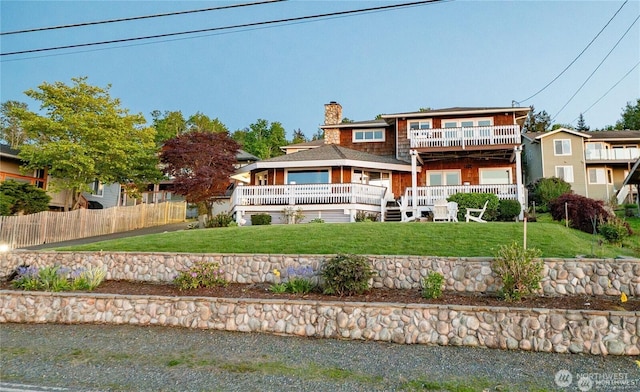 6926 Holeman Ave, Blaine, WA 98230 - rear view of house featuring fence, a wooden deck, a chimney, a balcony, and a yard