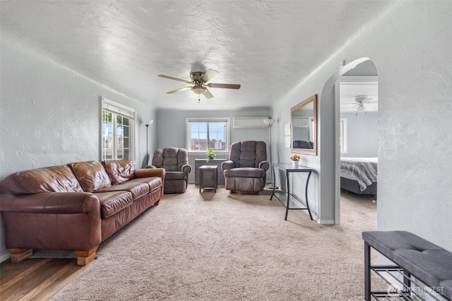 139 N Star Dr, Chehalis, WA 98532 - living area featuring a textured wall, an AC wall unit, a textured ceiling, arched walkways, and a ceiling fan