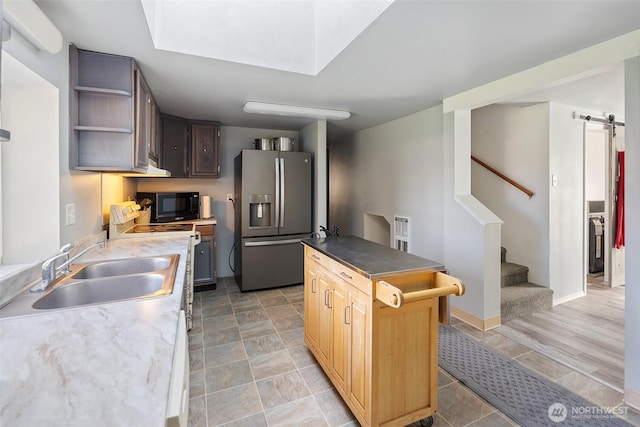 139 N Star Dr, Chehalis, WA 98532 - kitchen with a barn door, black microwave, a sink, stainless steel fridge with ice dispenser, and electric range