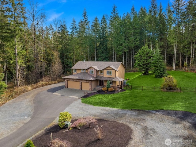 4111 161st Ave NE, Snohomish, WA 98290 - view of front of house featuring aphalt driveway, fence, a garage, a forest view, and a front lawn