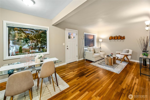 dining space with baseboards and hardwood / wood-style flooring