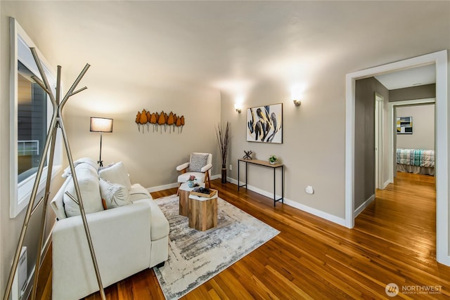 living area with baseboards and wood finished floors