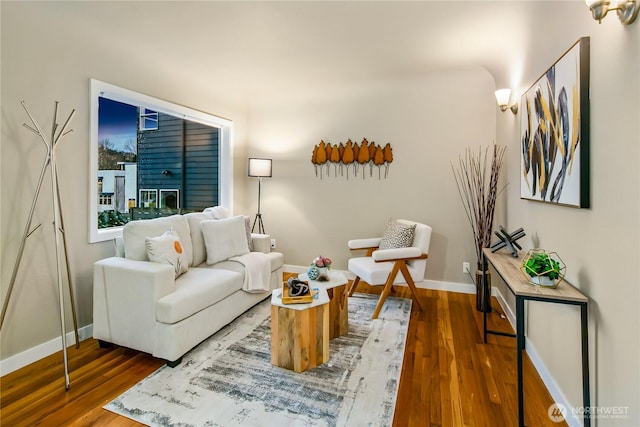 living area featuring baseboards and wood finished floors