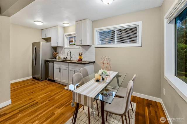 dining space with light wood finished floors and baseboards