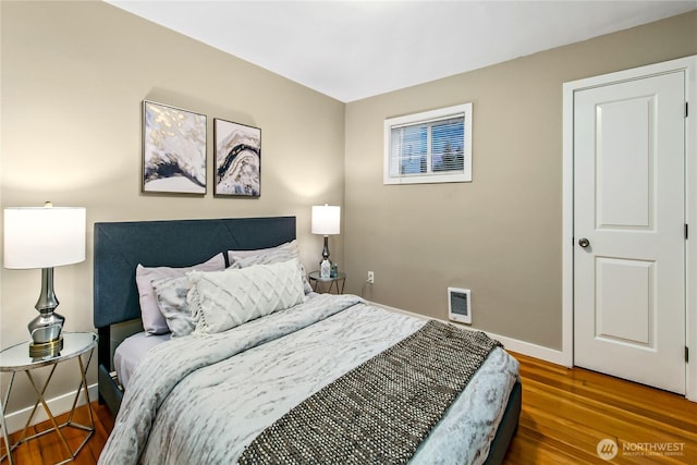 bedroom featuring wood finished floors and baseboards