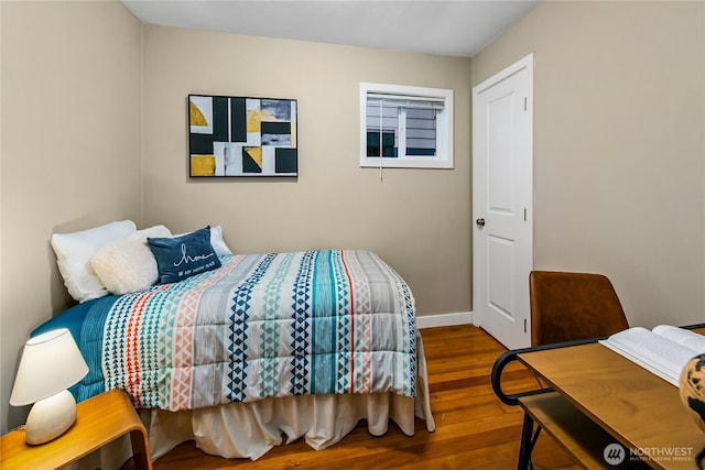 bedroom featuring baseboards and wood finished floors