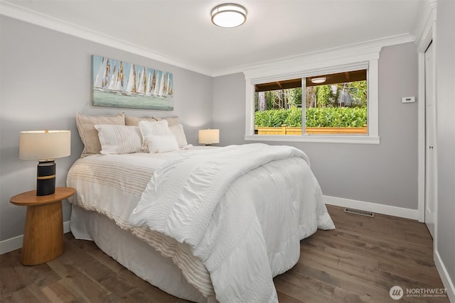 bedroom featuring wood finished floors, baseboards, and ornamental molding